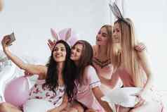 不错的未婚女子聚会，派对女孩粉红色的白色衣服坐在沙发自拍