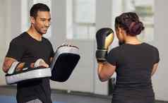 包权力拳拍摄年轻的男人。培训客户端拳击健身房