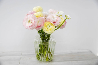 花束苍白的粉红色的黄色的波斯金凤花玻璃花瓶表格苍白的灰色的