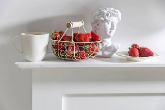 白色金属篮子木处理新鲜的草莓波纹陶瓷杯茶石膏阿波罗头米色表格生活