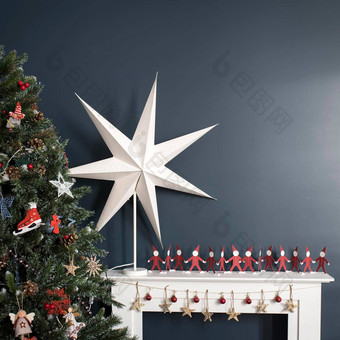 红色的纸但持有手白色大纸明星背景<strong>树人</strong>工壁炉背景黑暗蓝色的墙室内装饰圣诞节