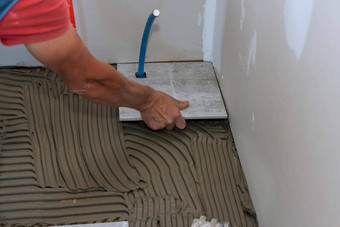 手工人铺设陶瓷瓷砖地板上