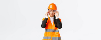 严肃的表情年轻的亚洲女<strong>建设</strong>经理遵循安全协议穿保护眼镜头盔进入<strong>企业</strong>站白色背景