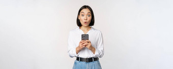 技术概念肖像亚洲女人移动电话女孩持有智能手机反应惊讶手机通知应用程序信息白色背景