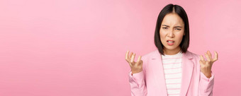 肖像愤怒的亚洲女人西装握紧的拳头愤怒的愤怒的smth坏站粉红色的背景