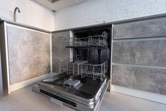 现代厨房空内置的洗碗机打开通过不锈钢钢台下厨房水槽利用水黑色的感应滚刀炊具安装白色工作台面白色语气厨房