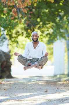 yogas浮动完整的长度拍摄英俊的年轻的男人。悬浮冥想公园