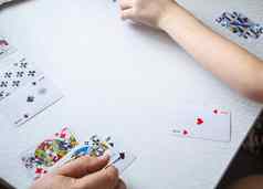 特写镜头男人的手孩子的手铺设玩卡片白色表格概念学习玩卡片