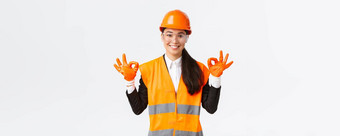 自信亚洲女<strong>建设工程</strong>师企业经理显示手势把安全头盔眼镜手套进入危险的区域白色背景