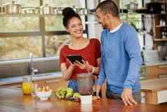 下载节食应用程序设计夫妻拍摄快乐年轻的夫妇数字平板电脑准备健康的零食首页