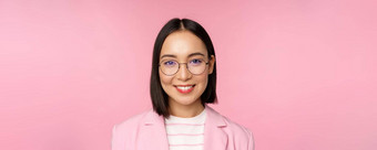 关闭肖像亚洲企业女人专业女商人眼镜微笑自信相机粉红色的背景