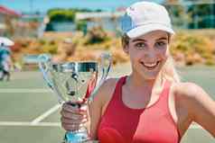 裁剪肖像有吸引力的年轻的女人持有奖杯赢得网球匹配一天