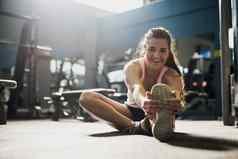锻炼进步拍摄年轻的女人拉伸练习健身房