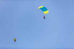 他降落树冠降落伞背景蓝色的天空特写镜头他降落降落伞