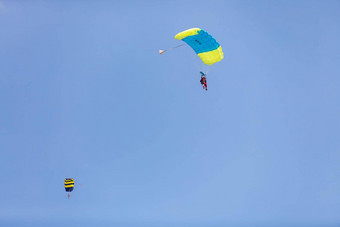 他降落树冠降落伞背景蓝色的天空特写镜头他降落降落伞