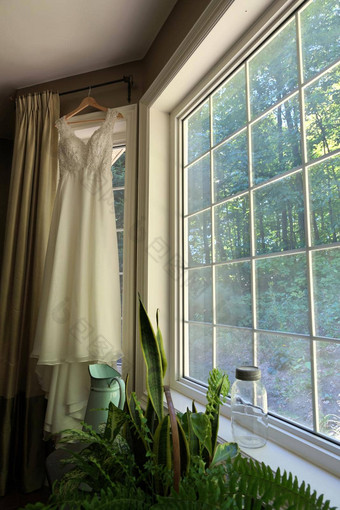 美丽的白色婚礼衣服挂窗口国家房子
