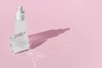血清化妆品瓶模型石英透明的棱镜水晶粉红色的背景玻璃棱镜折射光影响射线光
