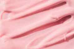 粉红色的颜色化妆品奶油乳液保湿霜涂片涂抹样本美奶油纹理背景皮肤护理产品中风特写镜头