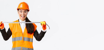 兴奋乐观的亚洲女建设工程师测量布局持有磁带测量微笑准备好了工作构建站白色背景安全头盔