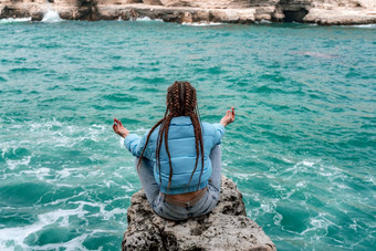 女人蓝色的夹克坐在岩石悬崖海<strong>狂风暴雨</strong>的海洋女孩旅行者休息认为梦想享受自然和平平静景观多风的天气