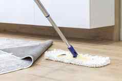 木地板上白色拖把清洁服务概念