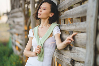 亚洲女人摆姿势烟草干燥流穿白色衣服绿色<strong>长筒靴</strong>