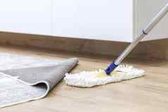 木地板上白色拖把清洁服务概念