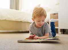 慢慢地学习读大单词拍摄年轻的男孩阅读书首页
