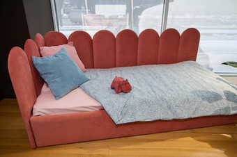 现代时尚的极简主义孩子们的沙发床上软明亮的珊瑚丝绒织物显示出售展厅最高质量家具商店