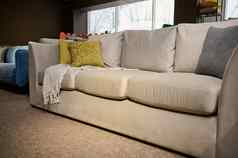 舒适的软垫丝绒米色沙发上彩色的灰色的绿色橄榄垫子显示出售家具商店展厅展览软垫家具
