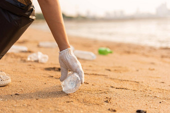 志愿者女人挑选塑料瓶<strong>垃圾</strong>塑料袋黑色的清洁海滩