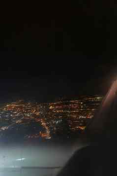 视图晚上发光的城市飞行飞机