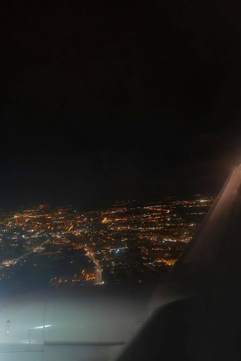 视图晚上发光的城市飞行飞机
