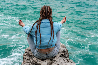 女人蓝色的夹克坐在岩石悬崖海<strong>狂风暴雨</strong>的海洋女孩旅行者休息认为梦想享受自然和平平静景观多风的天气