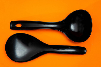 集<strong>厨房</strong>勺子抹刀黑色的塑料孤立的橙色<strong>背景厨房</strong>餐具