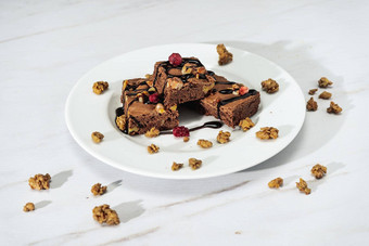 巧克力巧克力蛋糕广场胡桃木块巧克力线程格兰诺拉麦片自然健康的食物概念