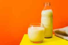 玻璃瓶大玻璃牛奶黄色的表格橙色背景