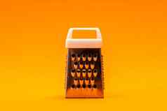 小闪亮的金属刨丝器孤立的橙色背景特写镜头奶酪食物不锈钢刨丝器水平取向
