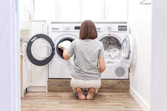 女人把衣服洗机洗