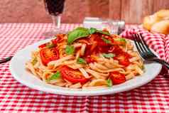 高视图意大利面意大利面美味的自制的番茄酱汁自制的罗勒叶子服务白色板红色的网纹桌布自然自制的食物概念