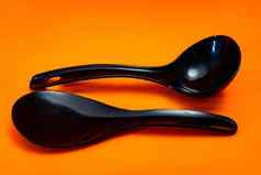 集厨房勺子抹刀黑色的塑料孤立的橙色背景厨房餐具