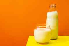 玻璃瓶大玻璃牛奶黄色的表格橙色背景