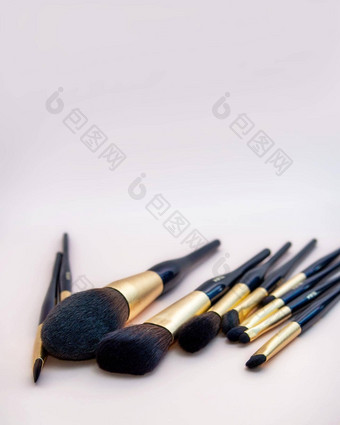 分类女化妆脸刷集专业黑暗蓝色的金化妆刷粉红色的背景