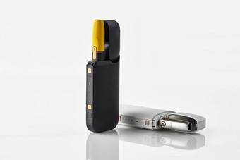 一代黑色的黄色的白色电子香烟开放电池孤立的白色加热烟草系统广告关闭