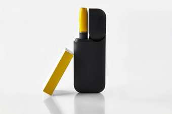 一代黑色的黄色的电子香烟开放电池火柴盒孤立的白色加热烟草系统广告关闭