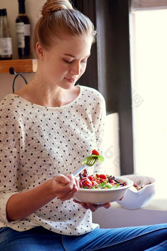 新鲜的健康的<strong>所以</strong>好拍摄年轻的女人吃健康的沙拉厨房