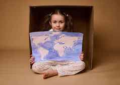 美丽的女孩马尾辫坐着内部纸板盒子海报画图像世界地图孤立的米色背景环境保护保存地球概念