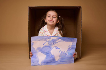 可爱的高加索人孩子年女孩坐着内部纸板盒子海报画图像世界地图孤立的米色背景环境保护保存地球概念