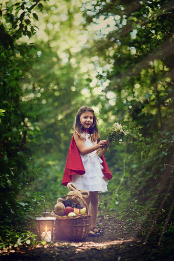 探索森林肖像女孩穿着红色的角持有花森林