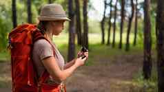 年轻的高加索人女人徒步旅行指南针森林